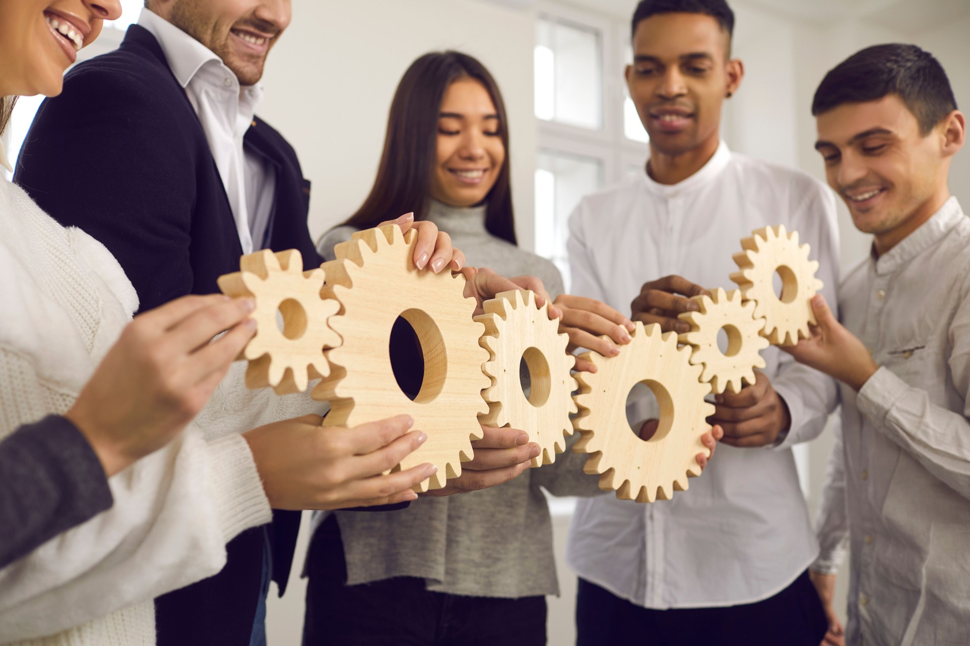 People joining gears as metaphor for well-coordinated work and building effective business system
